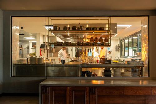 a kitchen with two chefs preparing food in a kitchen at INVENTIST Hotel Sports Academy Istanbul in Istanbul