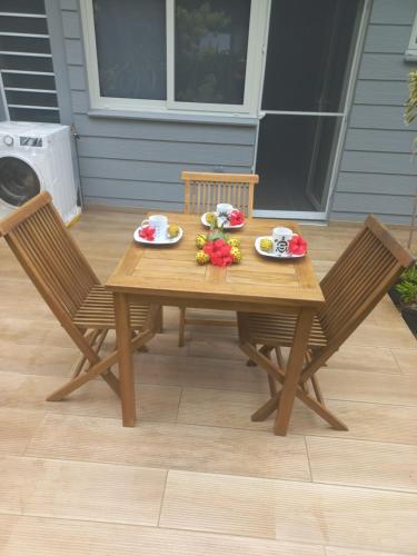 a wooden table with two chairs and plates of food on it at Fare Tapu in Uturoa