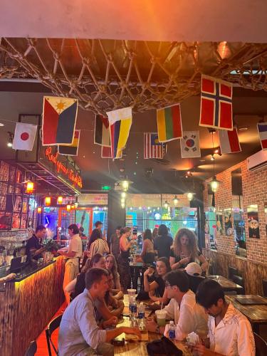een groep mensen die aan een tafel in een restaurant zitten bij Da Nang S Phuot Hostel in Da Nang