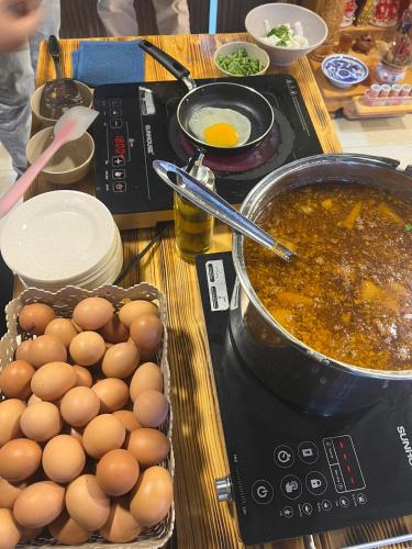 een tafel met eieren en een pot soep bij Da Nang S Phuot Hostel in Da Nang