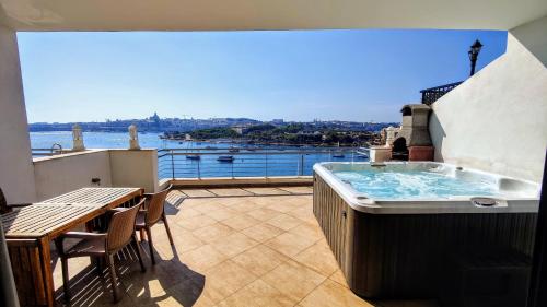 een hot tub op een balkon met uitzicht op het water bij Magic Seaview Deluxe 3BR with Hot Tub in Sliema