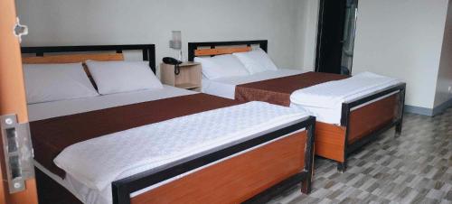 two beds in a hotel room with two bedsvisor at Matibag recreational hub resort and hotel in Candelaria