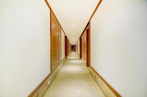 an empty corridor with white walls and a long hallway at Collection O 78675 Collection O Key Rooms in New Delhi