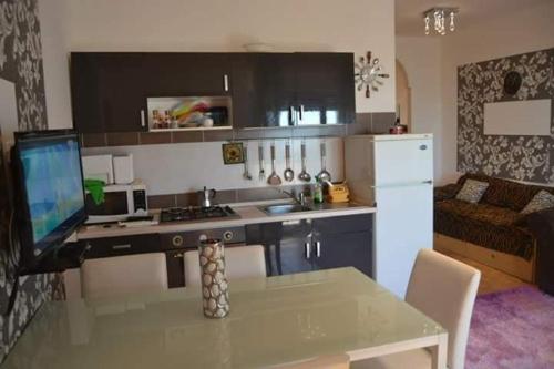 een keuken met een tafel en een keuken met een koelkast bij Terrazza sul Mare in Alba Adriatica
