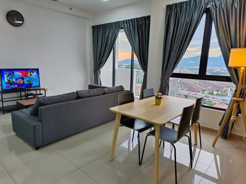 uma sala de estar com uma mesa e um sofá em Meritus Service Apartment em Perai