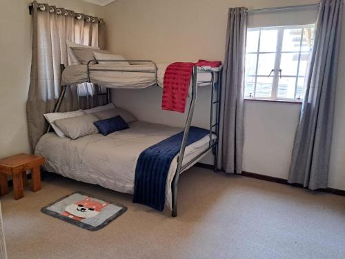 a bedroom with two bunk beds and a window at KASP Cottage in Underberg