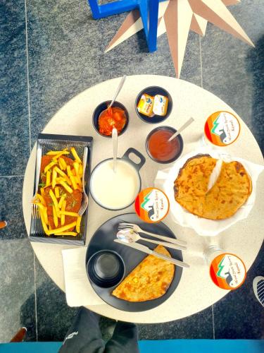 a white table with food on top of it at Hotel Wood Stock Luxury - A Boutique Property - Penthouse - Open Air Restaurant & Terrace in Kasauli