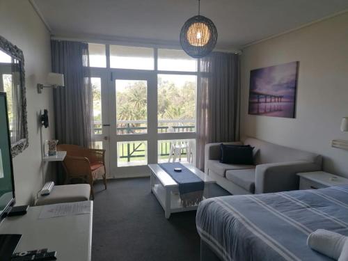 a hotel room with a bed and a living room at Brookes Hill Studio, Unit 156 in Port Elizabeth