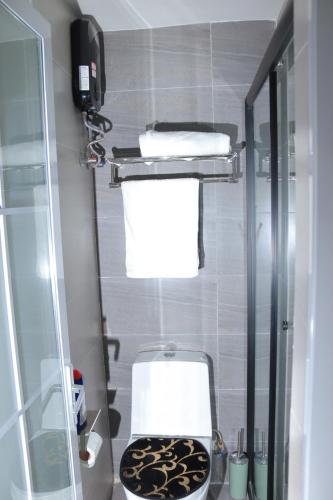 a small bathroom with a toilet and towels at CitiHeart Suite in Nairobi