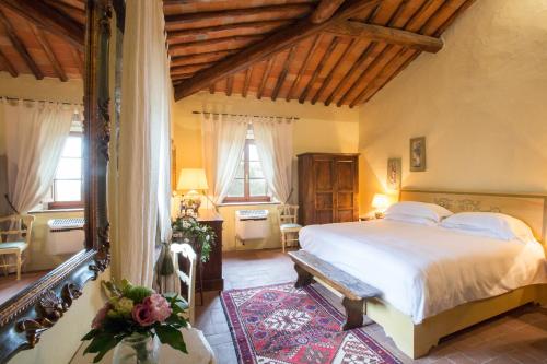 una camera con un grande letto in una stanza con soffitti in legno di Borgo Livernano - Farmhouse with pool a Radda in Chianti