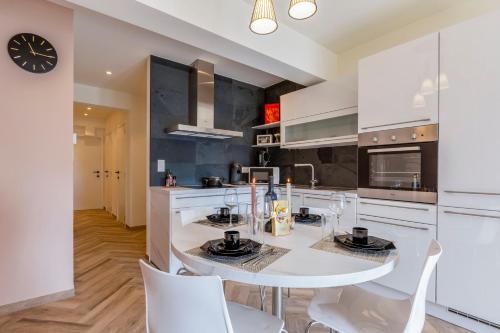 a kitchen with a white table and white chairs at EVA-Modern 2 bedroom apartment seaside Oostende in Ostend