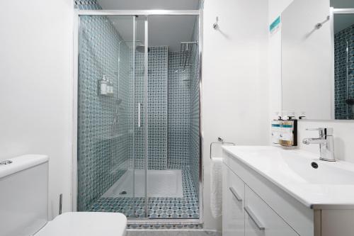 a bathroom with a shower and a toilet and a sink at Numa Seville Alegre in Seville