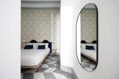 una camera con due letti e uno specchio di numa I Alegre Apartments a Siviglia