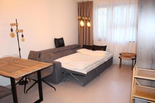 a living room with a couch and a table and a bed at PM Services Borovets Garden Apartments in Borovets