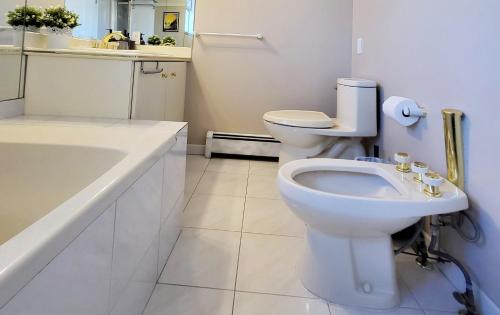 a white bathroom with a toilet and a sink at Vivi's Home in Vancouver