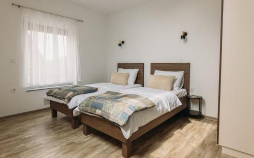a white bedroom with a large bed with two pillows at Hiša na Ravnah in Pišece