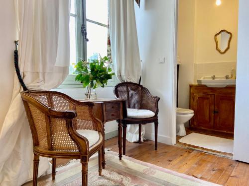 La salle de bains est pourvue de 2 chaises, d'un bureau et d'une fenêtre. dans l'établissement Chateau la Bainerie, à Tiercé