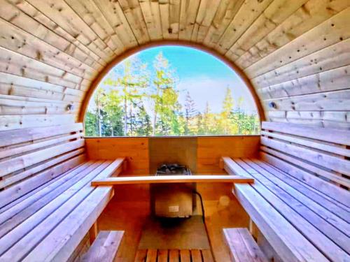 a wooden sauna with an oval window in it at Chalet in Bad Leonhard near Klippitztörl Slopes in Klippitztorl