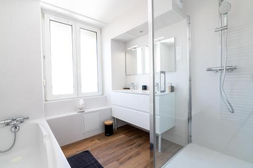 une salle de bain blanche avec une baignoire et un lavabo dans l'établissement Bleu des Vosges, à Gérardmer