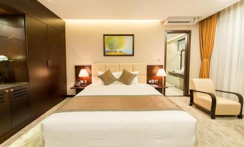 a hotel room with a large bed and a chair at Muong Thanh Hanoi Centre Hotel in Hanoi