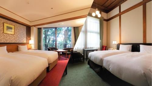 Nara Hotel في نارا: غرفة فندقية بسريرين ونافذة