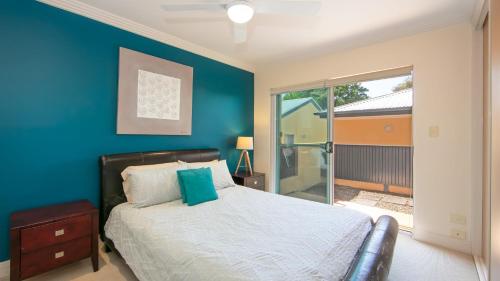 a bedroom with a bed and a blue wall at Riverview Apartment 1 Block 1 in Iluka
