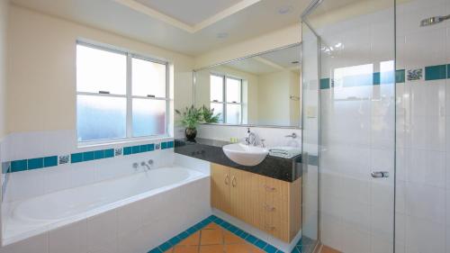 a bathroom with a tub and a sink and a shower at Riverview Apartment 1 Block 1 in Iluka