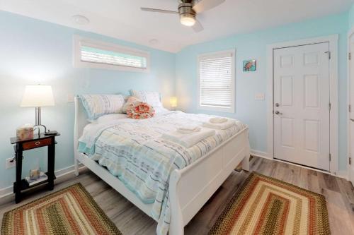 - une chambre avec un lit aux murs bleus et une fenêtre dans l'établissement Loggerhead Surf, à Kure Beach