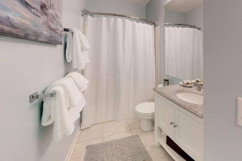 uma casa de banho branca com um WC e um lavatório em Sand Castle em Kure Beach