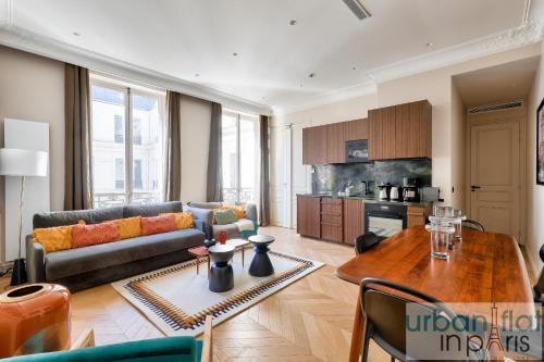 un salon avec un canapé et une table dans l'établissement 141 - Beautiful Flat Triangle d Or Champs Elysees, à Paris