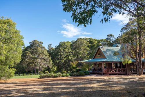 a building with a blue roof with trees in the background at Tintagel Estate I Private Properties in Forest Grove