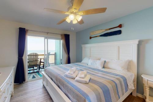 a bedroom with a bed and a ceiling fan at Easy Breezy in Carolina Beach