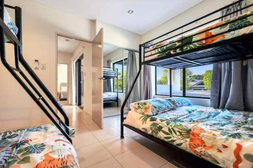 Beautiful Bayview - King Beds, Pool Water Frontage في Stuart Park: غرفة نوم بسريرين بطابقين وشرفة