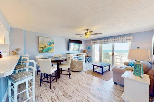 a kitchen and living room with a table and chairs at Saltwater Kure in Kure Beach