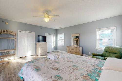 ein Schlafzimmer mit einem Bett, einem Sofa und einem TV in der Unterkunft Blue Heron Nest in Carolina Beach