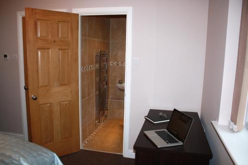 a bedroom with a laptop on a desk next to a shower at B&B Dorwyn Manor in Avebury