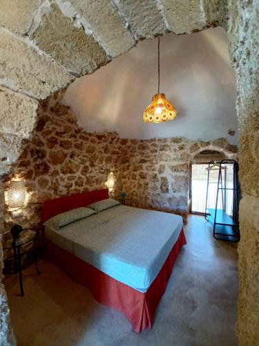 a bedroom with a bed in a stone wall at Tenuta La Milogna in Gallipoli