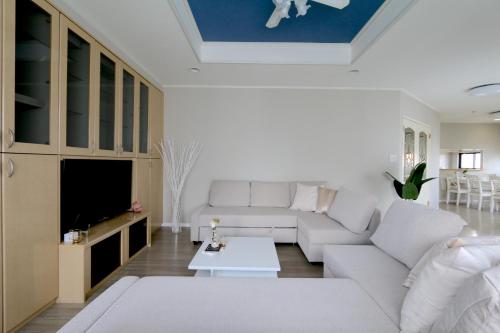 a living room with a white couch and a tv at ELLE Namba Villa in Osaka