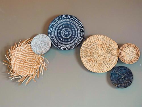 four straw hats are hanging on a wall at Wag Hill Lodge & Spa in Mwanza