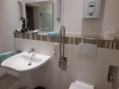 La salle de bains est pourvue d'un lavabo et d'un miroir. dans l'établissement Gästezimmer Bernkastel - Gästehaus Barbara, à Bernkastel-Kues