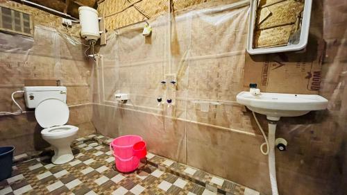 a bathroom with a toilet and a sink at HAPPY PLACE HAMPI in Hampi