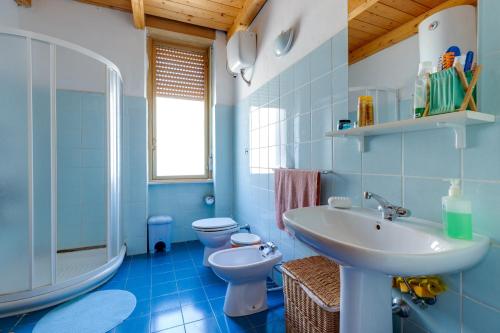 een blauwe badkamer met een wastafel en een toilet bij Paradibosa in Bosa