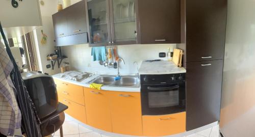 a kitchen with orange cabinets and a black refrigerator at Casa Nunù in Taranto