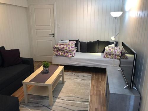 a living room with a bed and a coffee table at Leilighet 1 og 2 - Mandal, Norges sørligste kommune in Ime