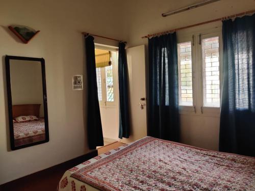 sypialnia z łóżkiem, lustrem i oknami w obiekcie Private room with a view w mieście Dehradun