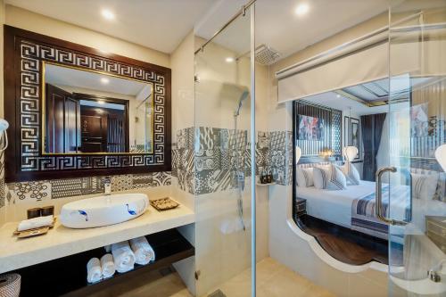 bagno con letto, lavandino e doccia di Le Pavillon Hoi An Luxury Resort & Spa a Hoi An