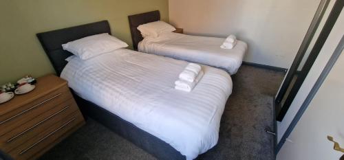 two beds with white sheets and pillows in a room at Vale of York restaurant and rooms in Thirsk