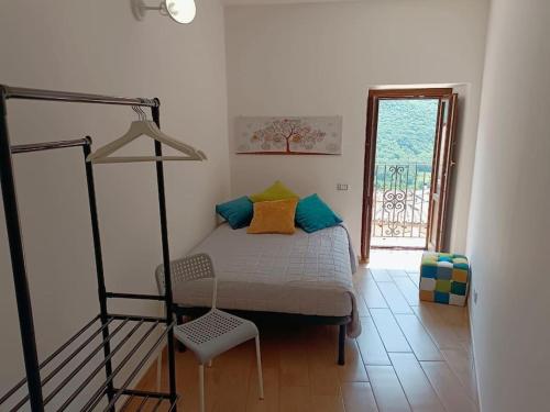 a bedroom with a bed and a chair and a window at Casa Mastro Pietro in Fontecchio