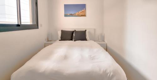 a large white bed in a white room with a window at BnBIsrael apartments - Ben Yehuda Nuage in Tel Aviv