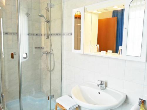a white bathroom with a sink and a shower at Gästehaus zur weißen Rose in Furth